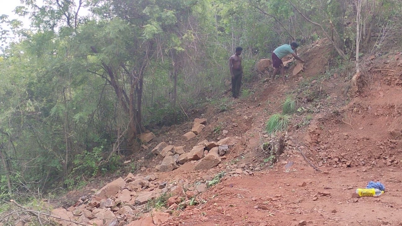 Rock being thrown down from the hill above into the pit.