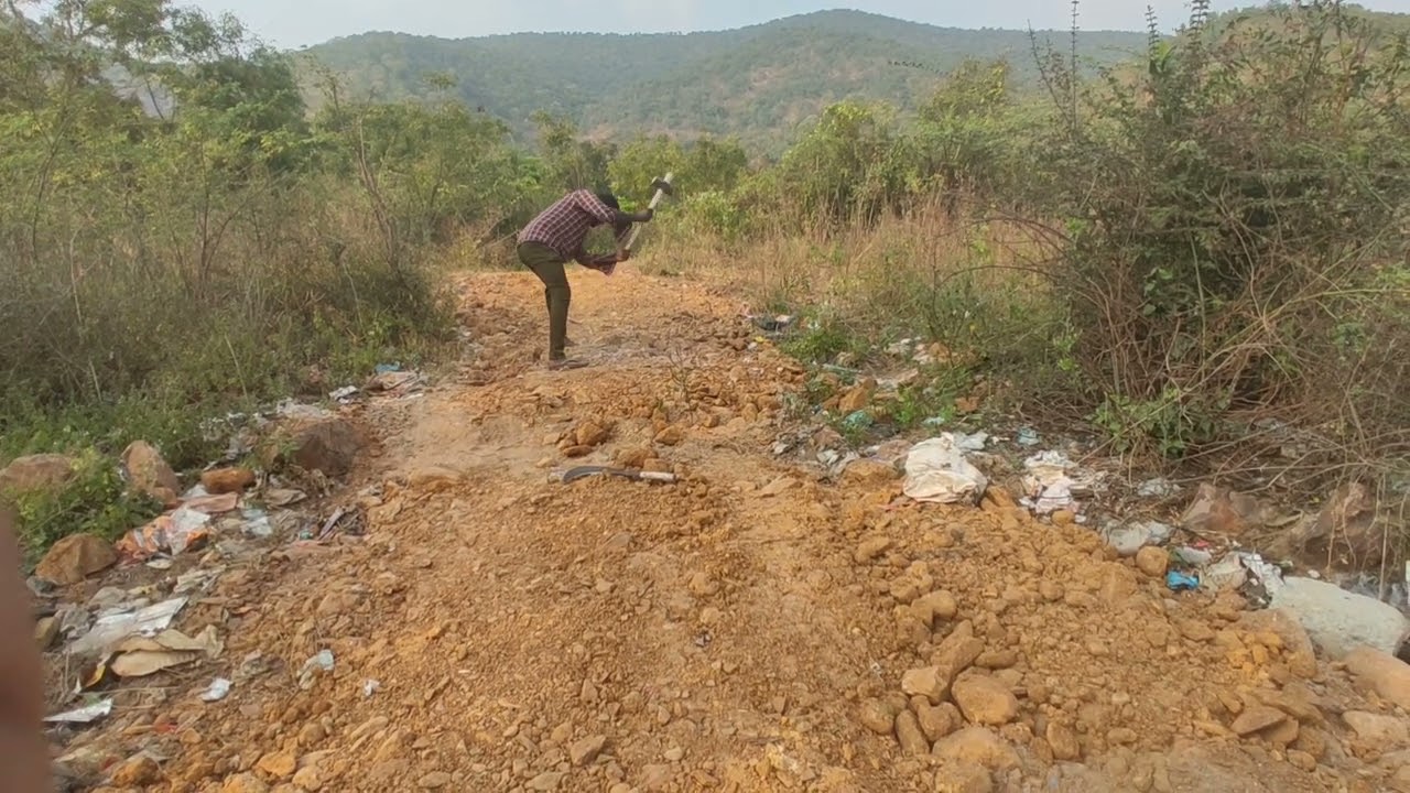 Rock being broken and cleared so a vehicle could get through.